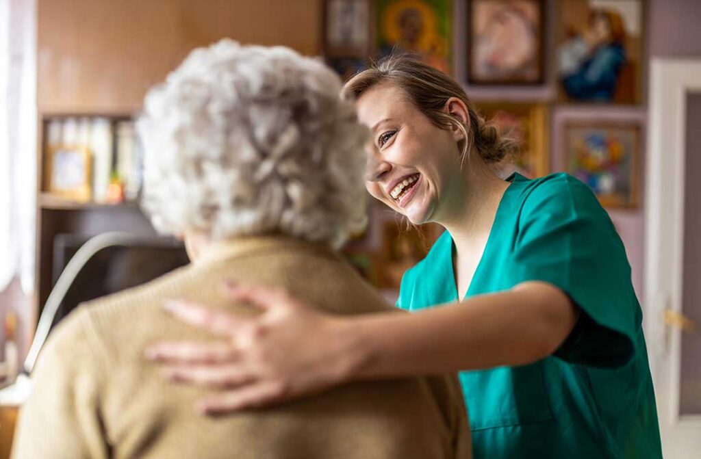 An older adult packing family photos and keepsakes into moving boxes in a bright, organized living room.