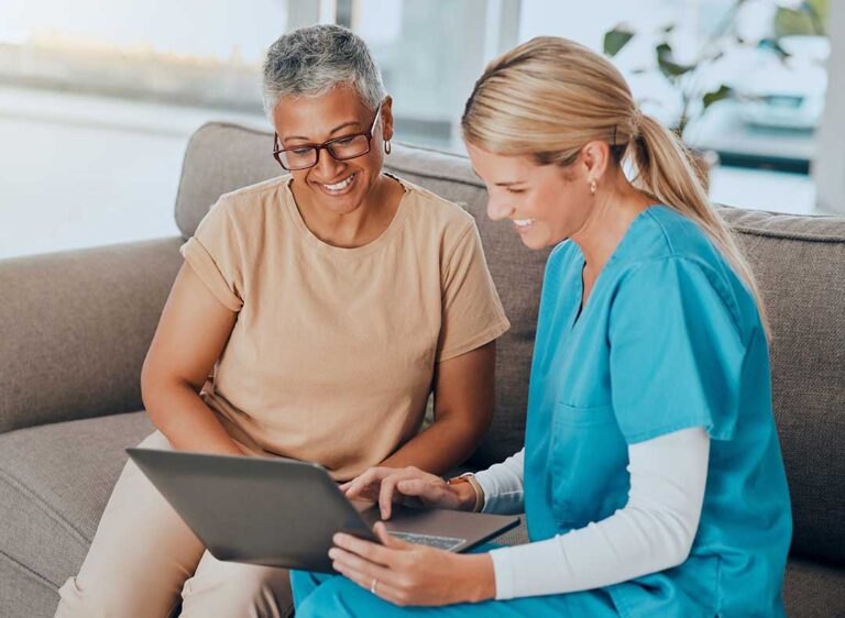 An elderly couple reviews paperwork with a family member at a kitchen table, discussing care options and finances.